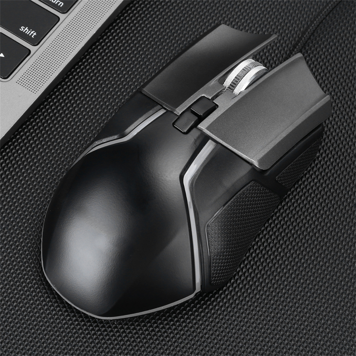Eine schwarze Computermaus auf strukturierter Oberfläche. Die Maus hat Tasten und ein Scrollrad.