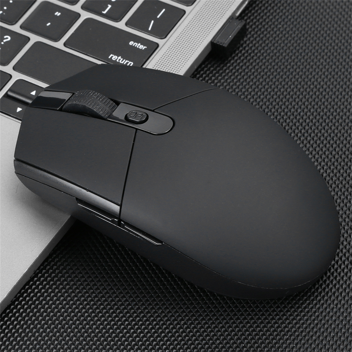 Schwarze kabellose Maus auf einer Laptop-Tastatur, schräge Ansicht.