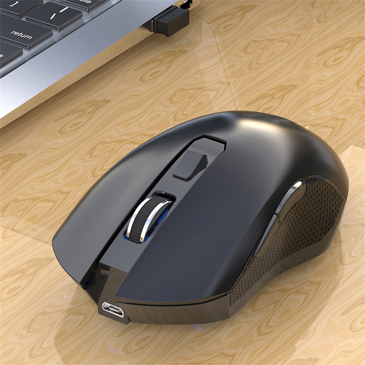 Schwarze Maus auf Holzschreibtisch. Scrollrad und USB-Anschluss sichtbar.