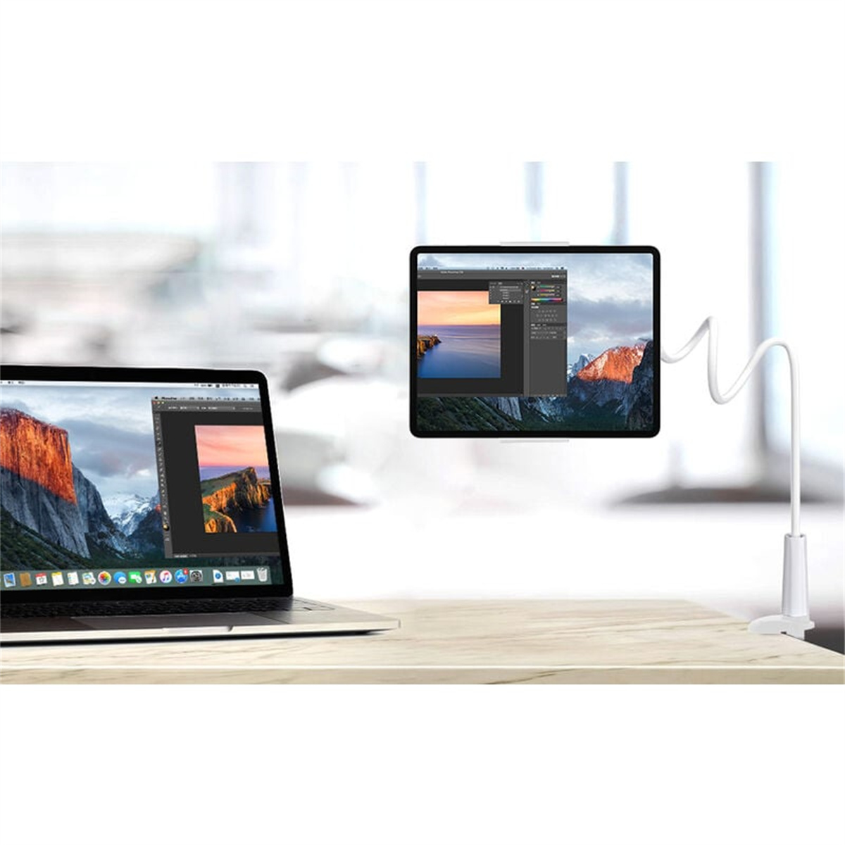 Laptop und Tablet auf einem Schreibtisch. Das Tablet befindet sich auf einem flexiblen Arm und zeigt eine Photoshop-ähnliche Oberfläche.