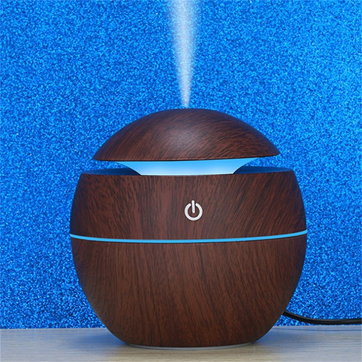 Ein brauner Diffusor für ätherische Öle aus Holz, mit einem blauen Schein von oben.
