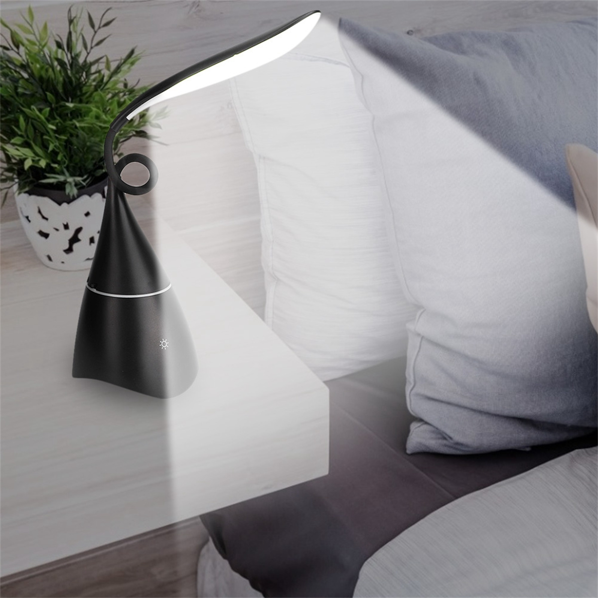 Schwarze Schreibtischlampe mit einem Scheinwerfer. Die Lampe steht auf einem Schreibtisch.