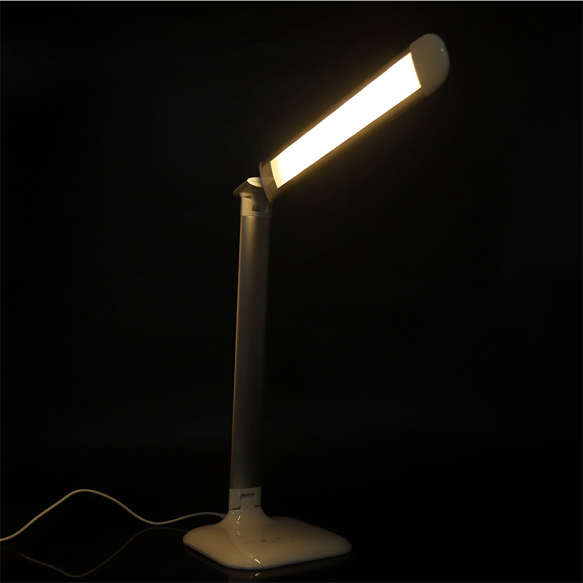 Schreibtischlampe mit rechteckigem LED-Licht, zur Kamera geneigt. Schwarzer Hintergrund.