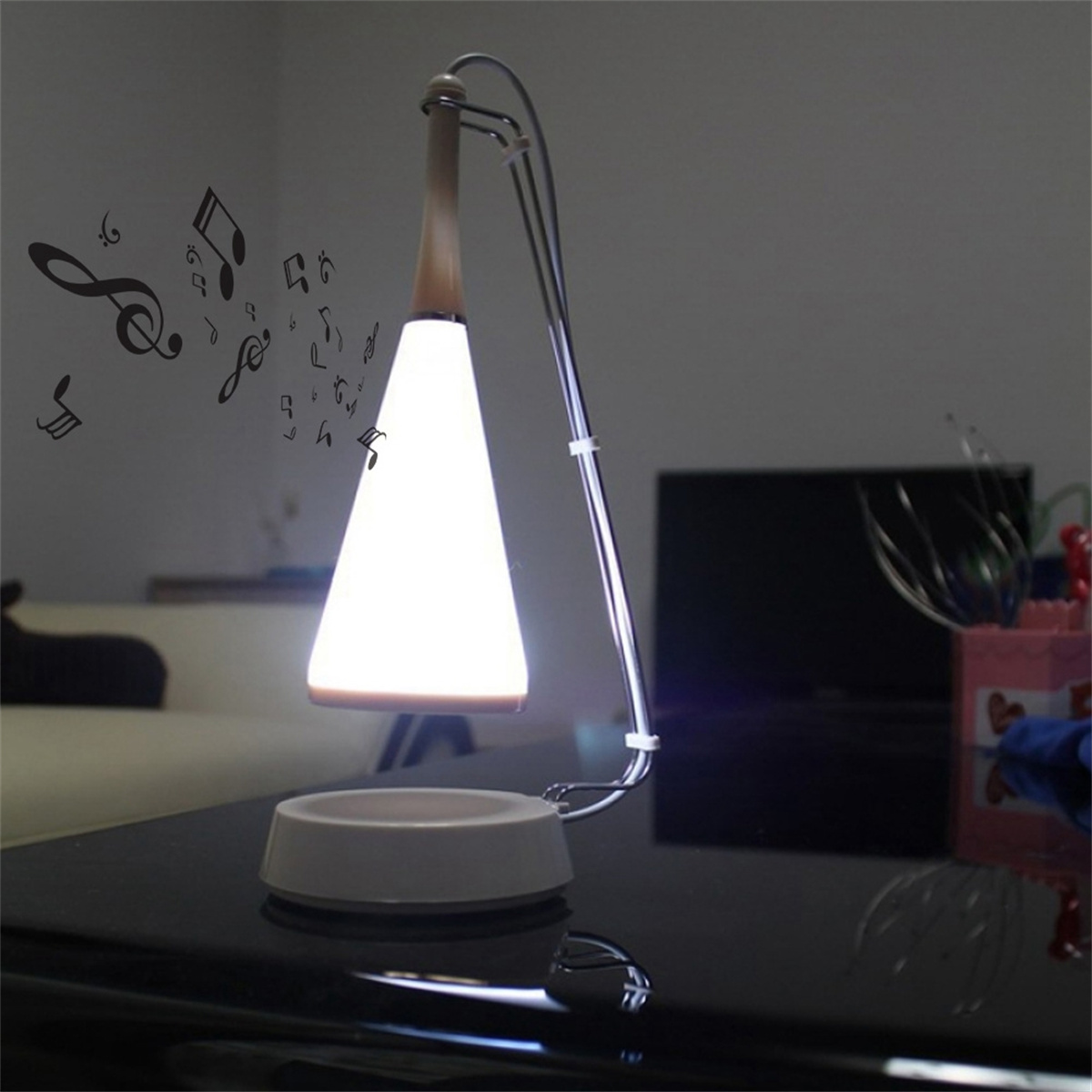 Moderne Lampe mit Noten. Noten schweben herum. Weißes Licht, schwarzer Hintergrund.