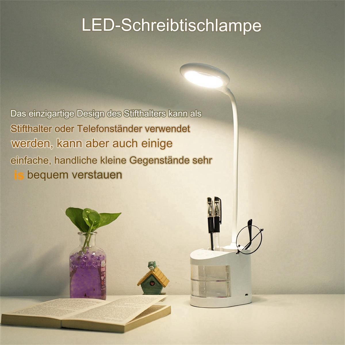Eine weiße Schreibtischlampe mit Stifthalter, einem Buch und einem kleinen Haus auf einem Tisch.