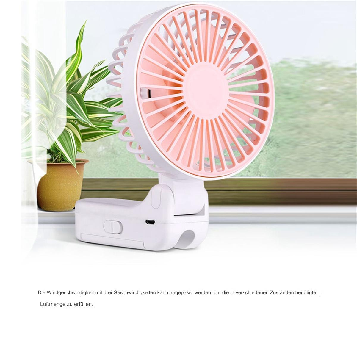 Kleiner weiß-rosa tragbarer Ventilator auf einer Fensterbank, neben einer grünen Pflanze.