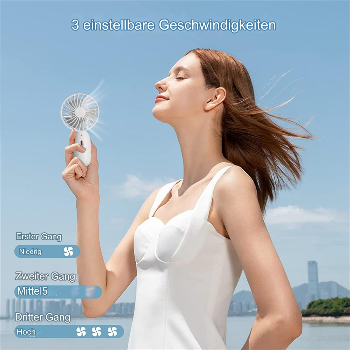 Eine Frau benutzt einen weißen tragbaren Ventilator im Freien unter blauem Himmel.