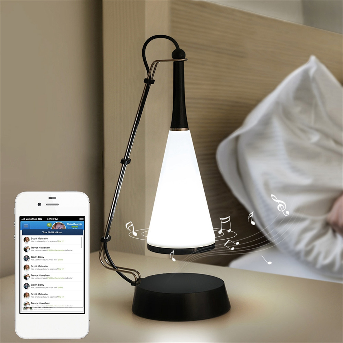 Eine Lampe mit Telefon daneben, das eine Benachrichtigung anzeigt, auf weißem Nachttisch.