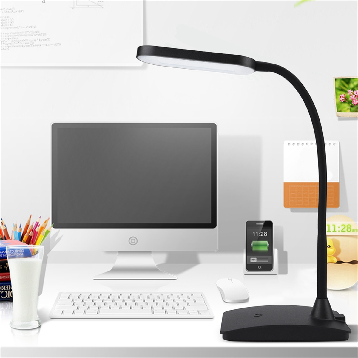 Ein Schreibtisch mit Computer, Tastatur, Telefon und einer Schreibtischlampe mit flexiblem Hals.