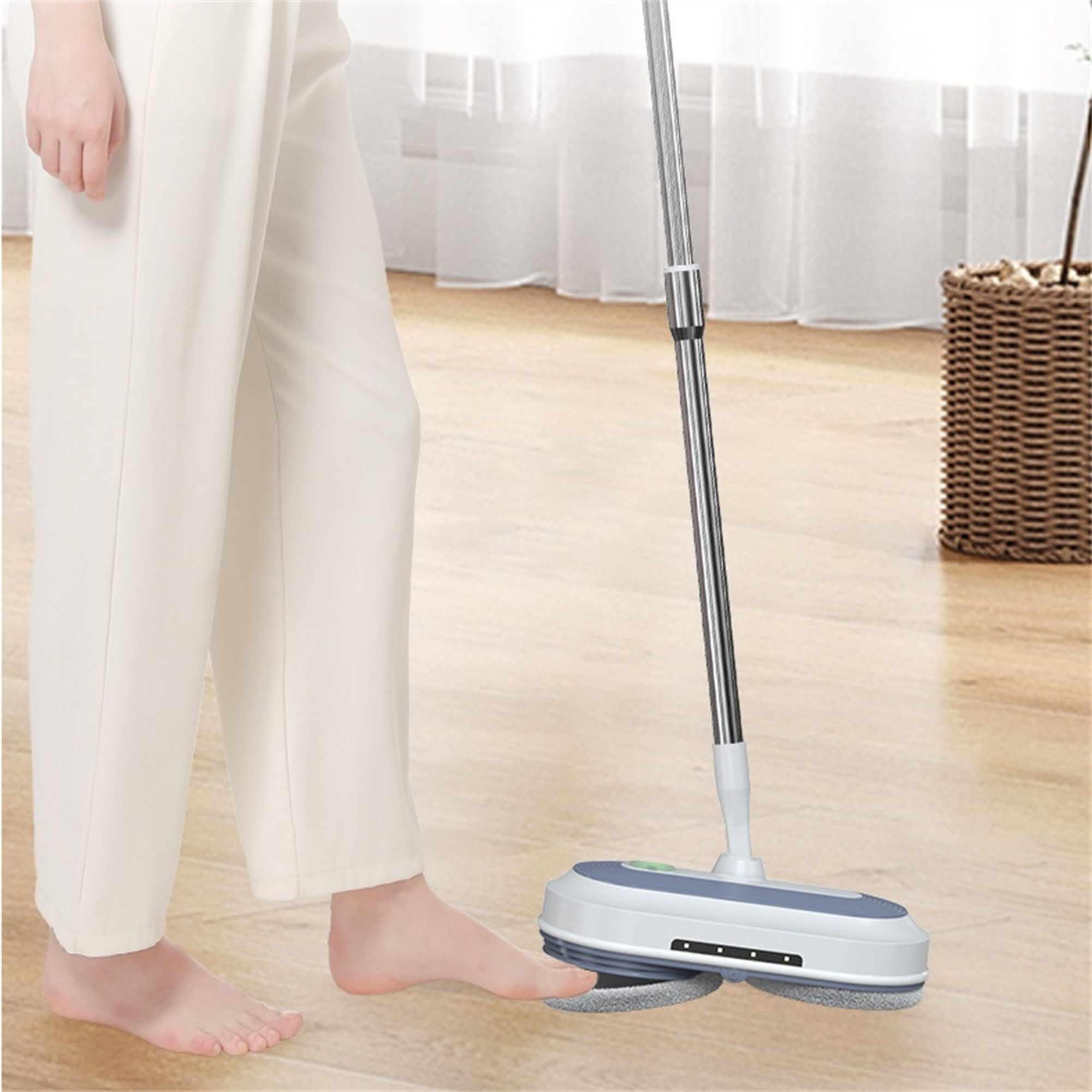 Fuß einer Person berührt einen Bodenwischer auf einem Holzboden. Der Wischer hat ein Pad.