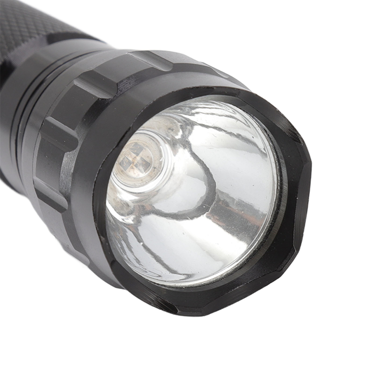 Schwarze Taschenlampe. Die Linse reflektiert Licht. Schwarzes Metallgehäuse.