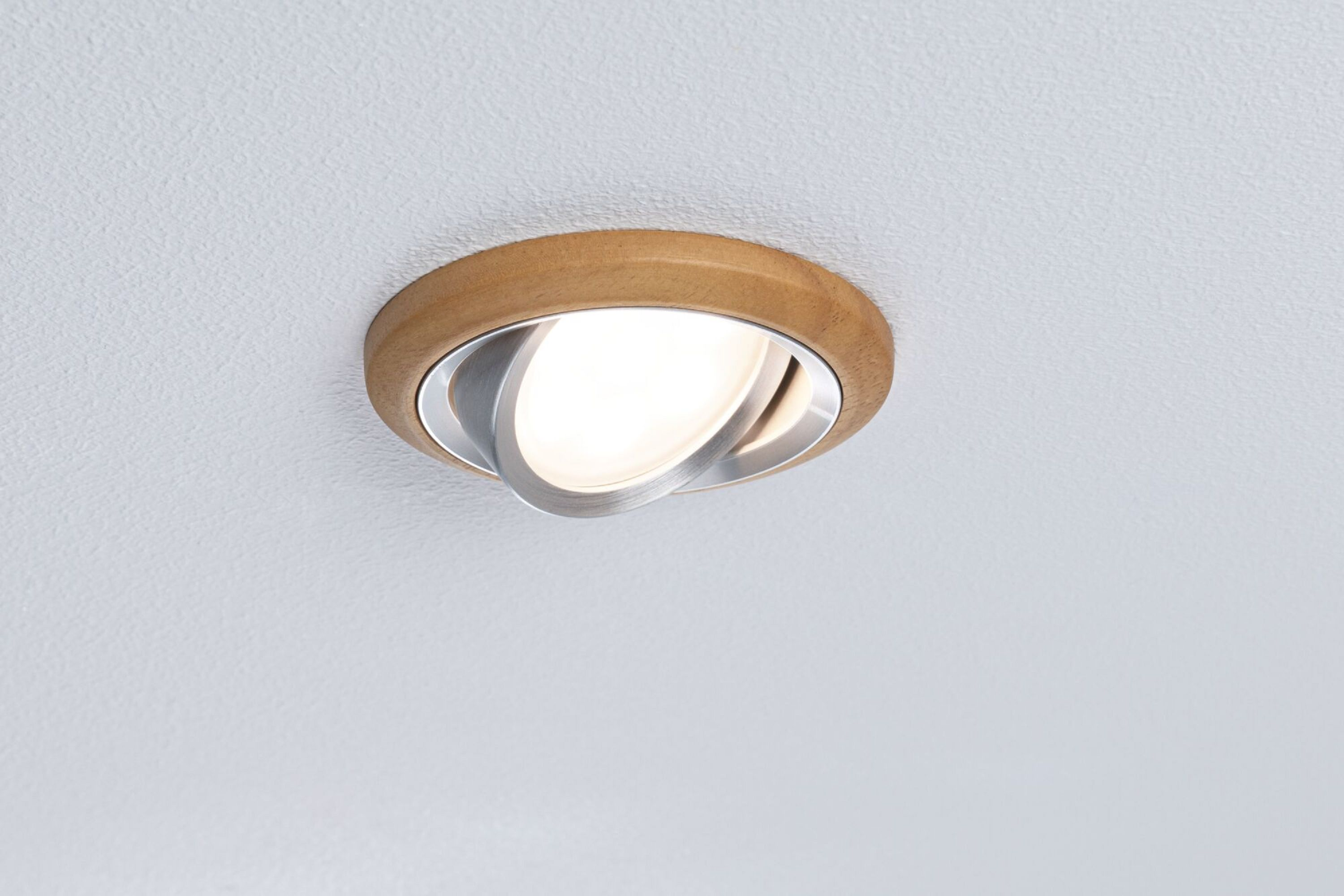 Wpuszczana lampa sufitowa z drewnianą obwódką i srebrnym światłem.