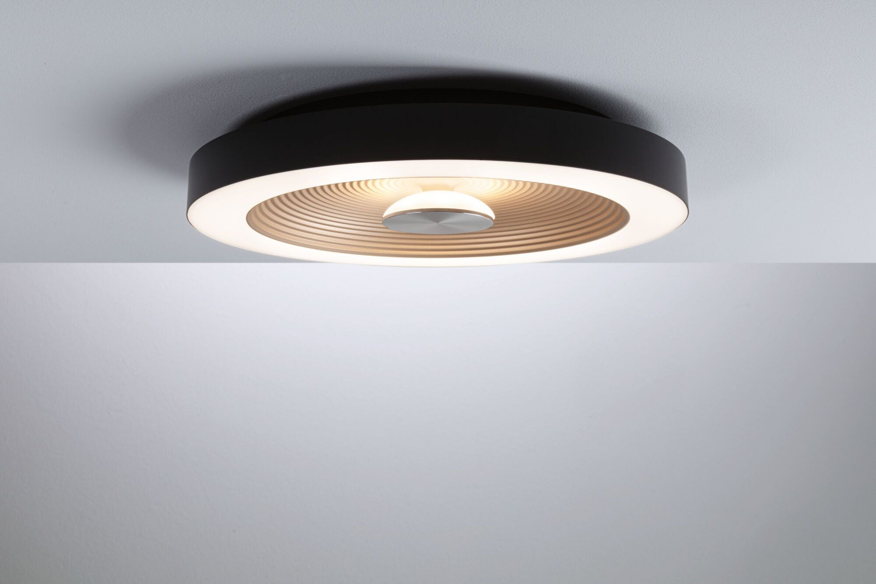 Schwarze kreisförmige Deckenleuchte mit konzentrischem Design und zentraler Lichtquelle.