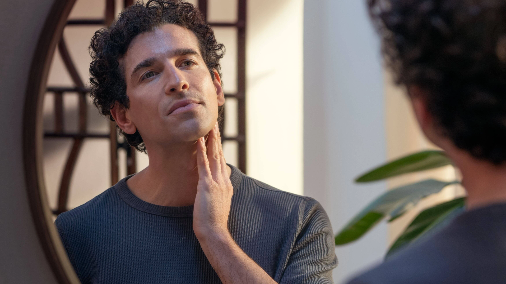 Mężczyzna ogląda swoją twarz w lustrze po goleniu.