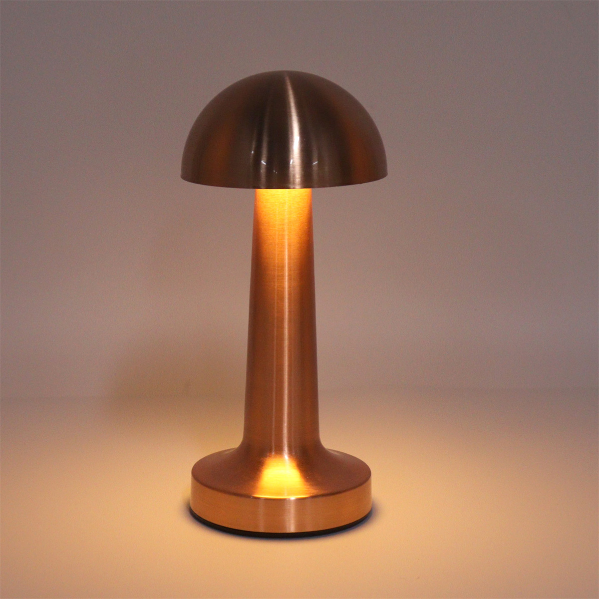 Eine kupferfarbene Lampe mit pilzförmigem Kopf und langem Stiel. Der Hintergrund ist hell.