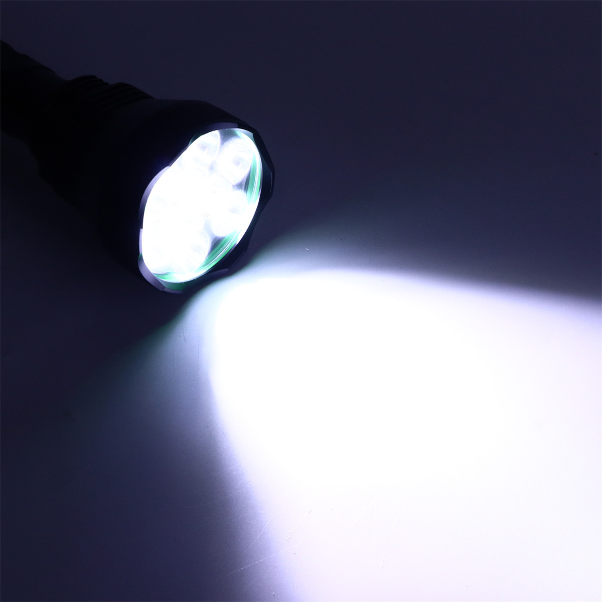 Eine Taschenlampe leuchtet hellweiß. Die Lichtquelle befindet sich oben links und scheint nach rechts.