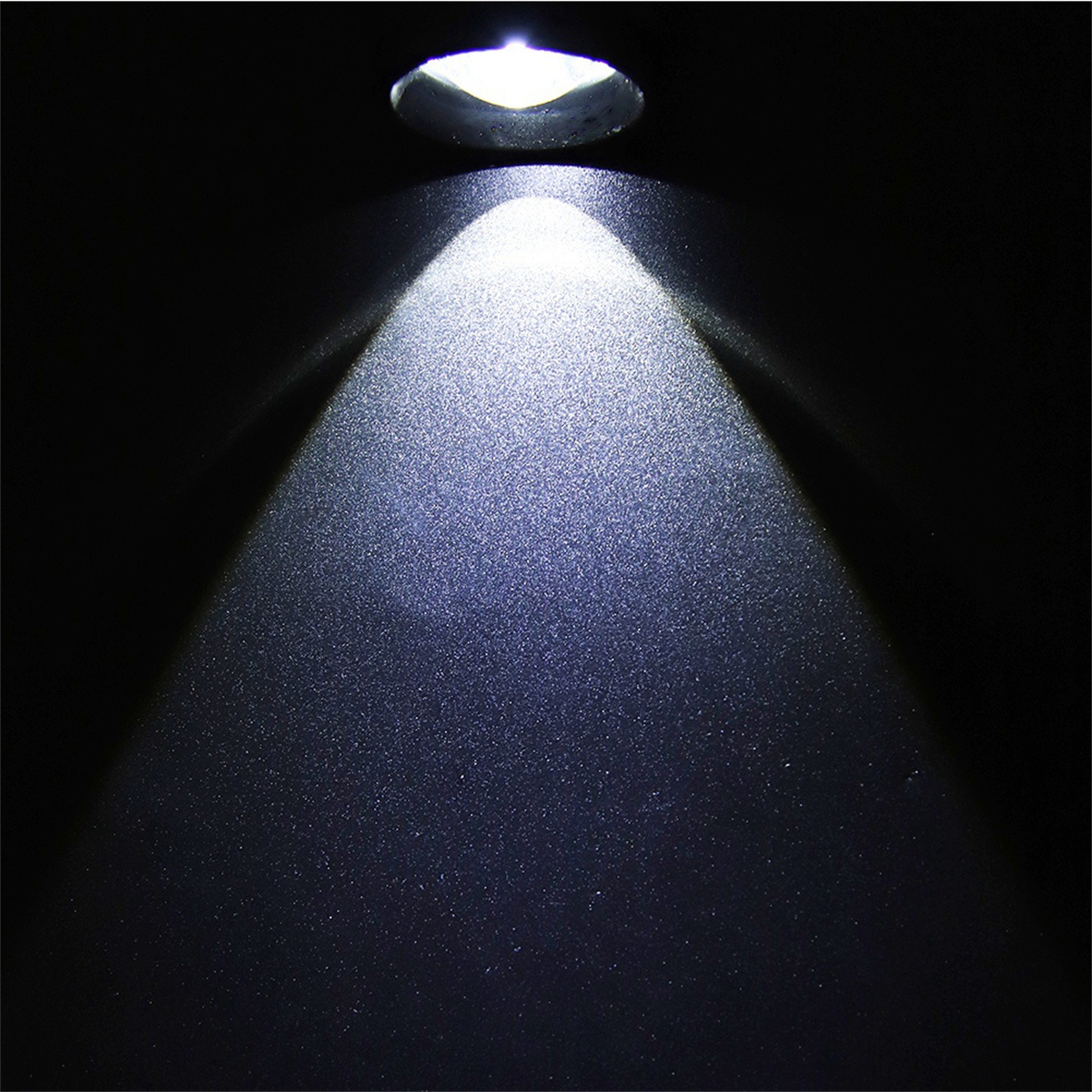 Weißer Lichtstrahl scheint auf schwarze Oberfläche. Das Licht ist fokussiert.