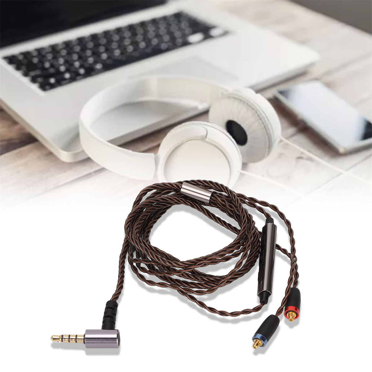 Kopfhörerkabel mit Anschlüssen, Kopfhörer und Laptop im Hintergrund.