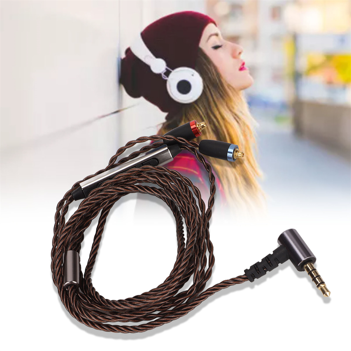 Kopfhörer mit Kabel, Frau im Hintergrund, trägt Hut und lehnt an einer Wand.