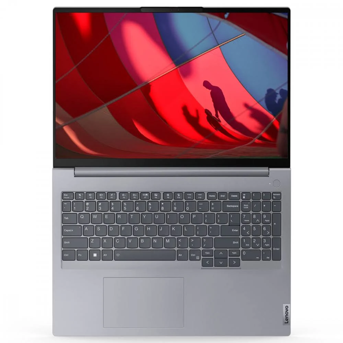El portátil muestra una imagen abstracta roja y azul. Se ven el teclado y el panel táctil. El portátil es gris plateado con un logotipo de Lenovo.