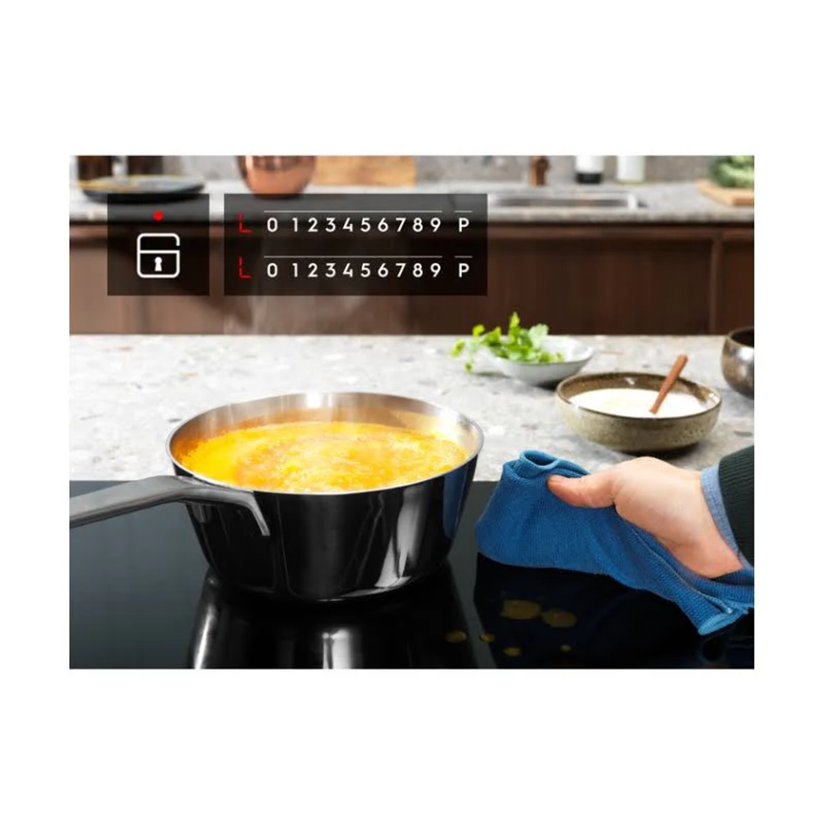 Garnek z zupą stoi na płycie grzejnej, a czyjaś dłoń wyciera powierzchnię. Widoczne cyfry i ikona kłódki.