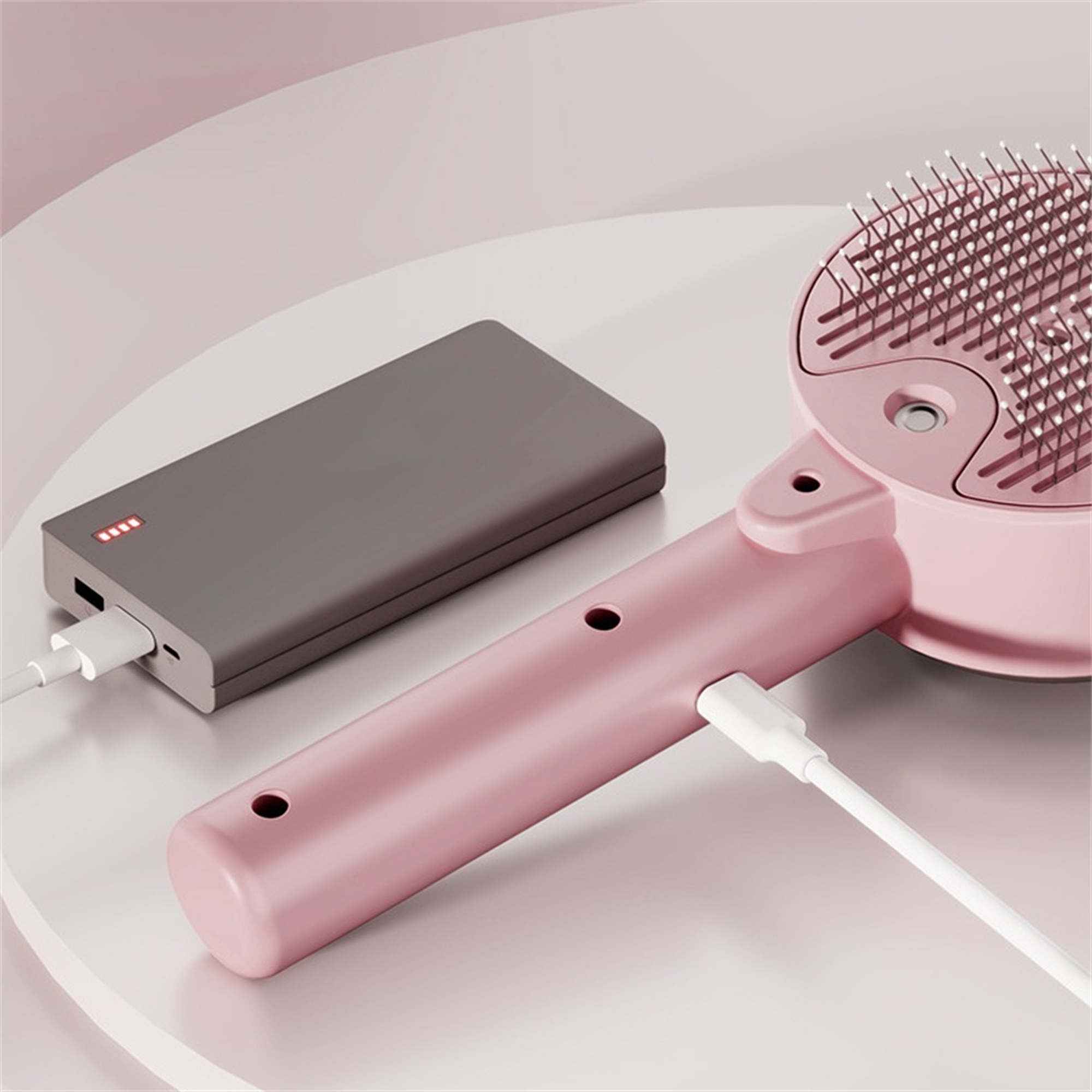 Eine rosa Haustierbürste mit Griff und einer angeschlossenen Powerbank.