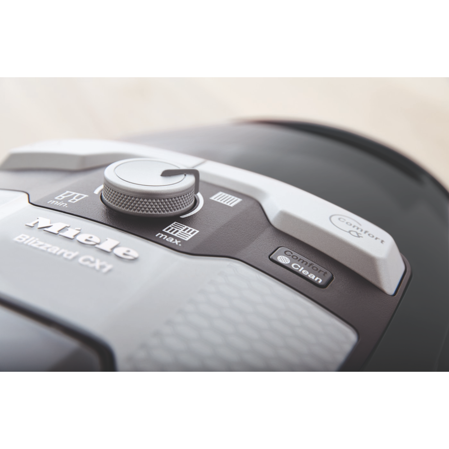 Primo piano del pannello di controllo di un aspirapolvere. Presenta un selettore di alimentazione, pulsanti e il logo Miele Blizzard CX1.