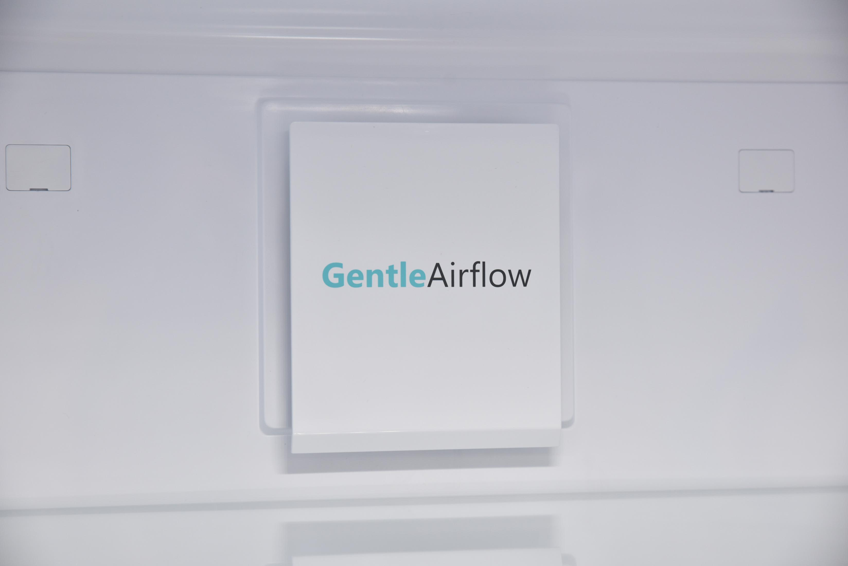 Inneres eines weißen Kühlschranks, zeigt ein weißes Paneel mit dem Text GentleAirflow.
