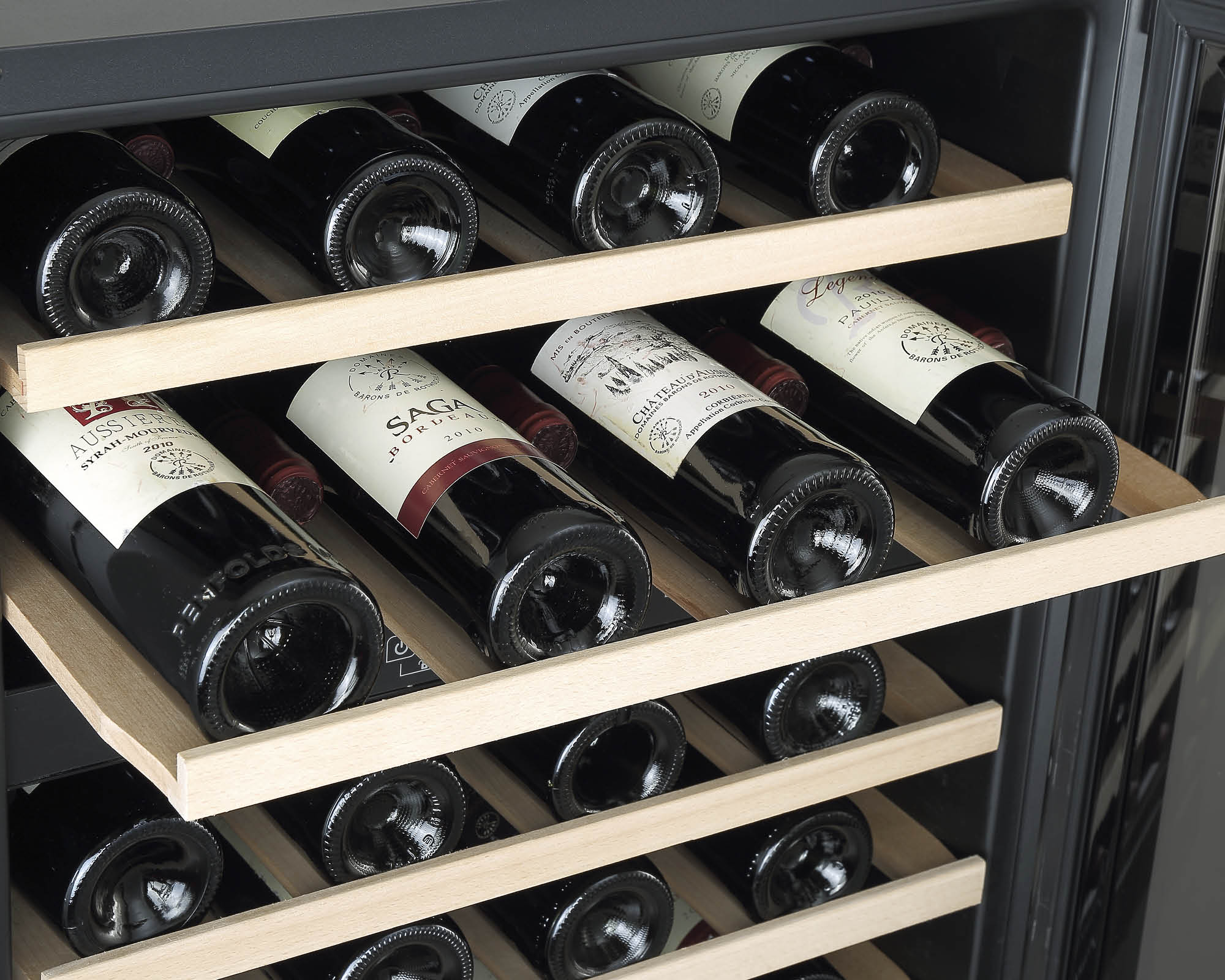 Botellas de vino en un enfriador de vino en estantes de madera.