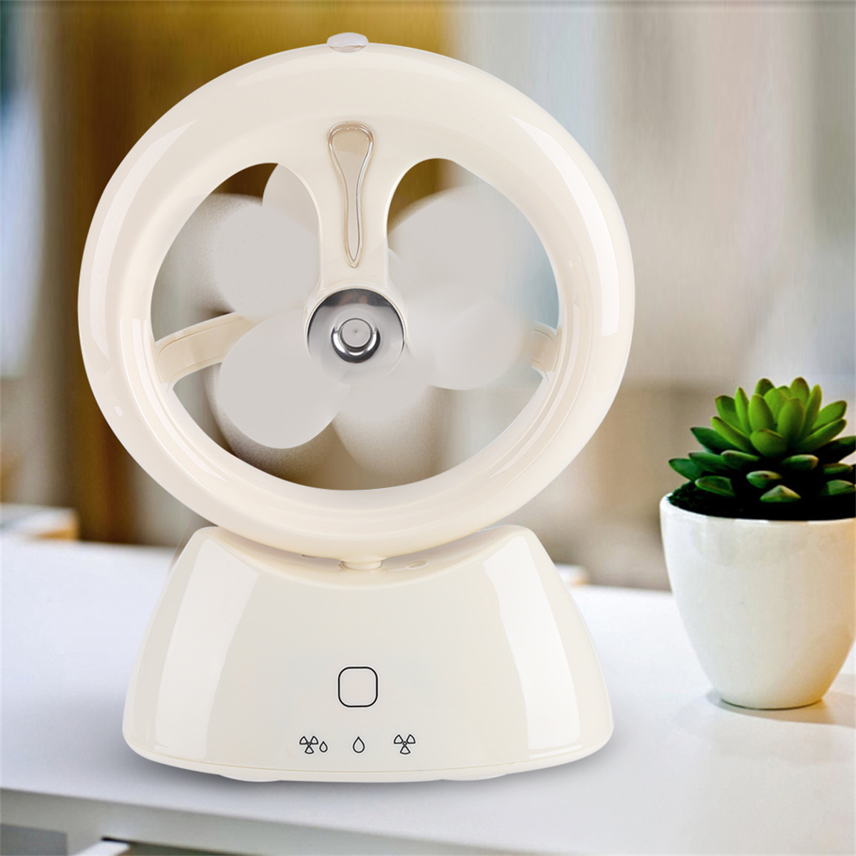Cremefarbener Ventilator mit drei Flügeln, ringförmigem Rahmen und Sockel. Kleine Pflanze daneben.