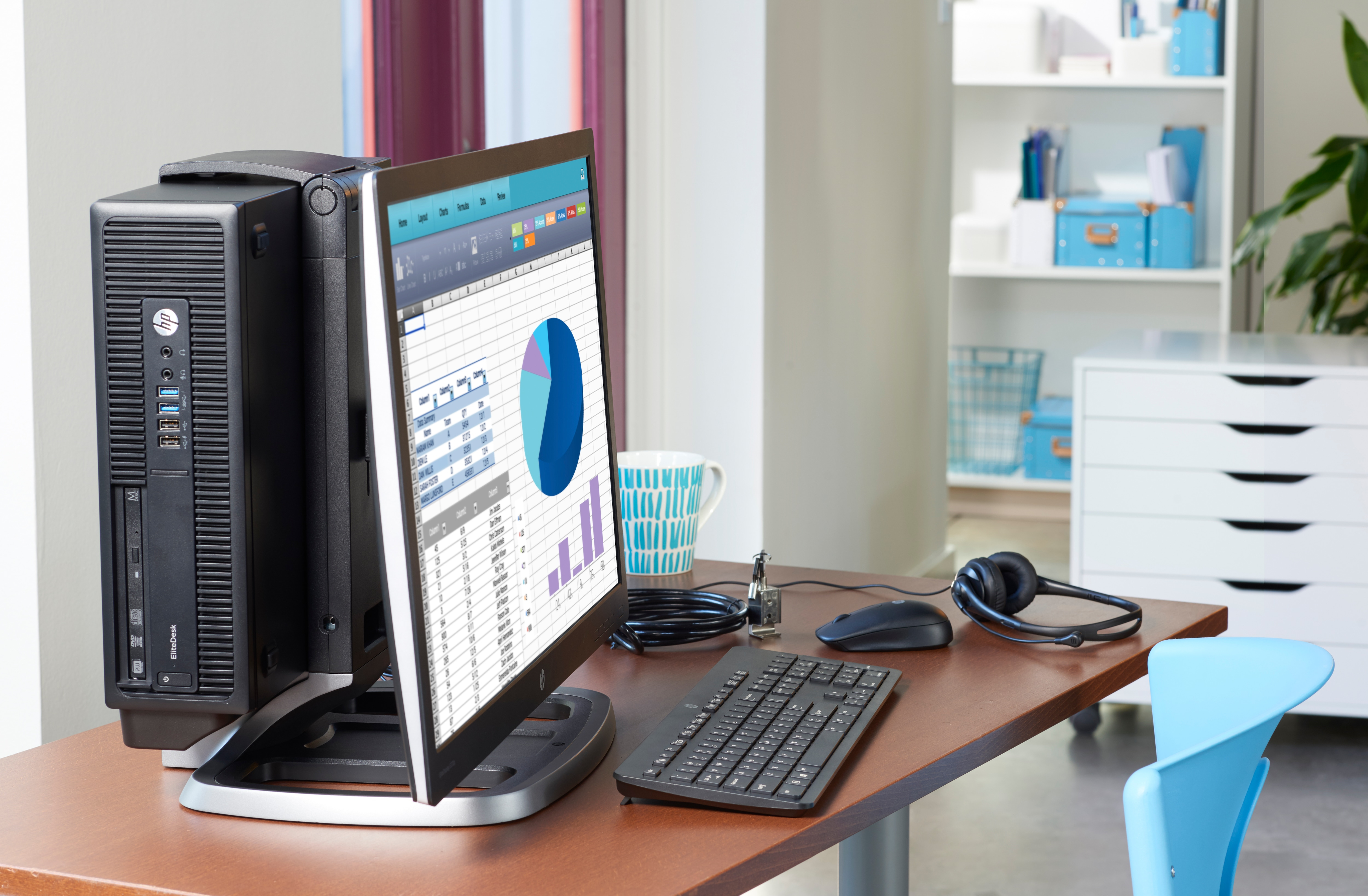 Un escritorio con un monitor que muestra un gráfico. Hay una torre de computadora, un teclado y un ratón.