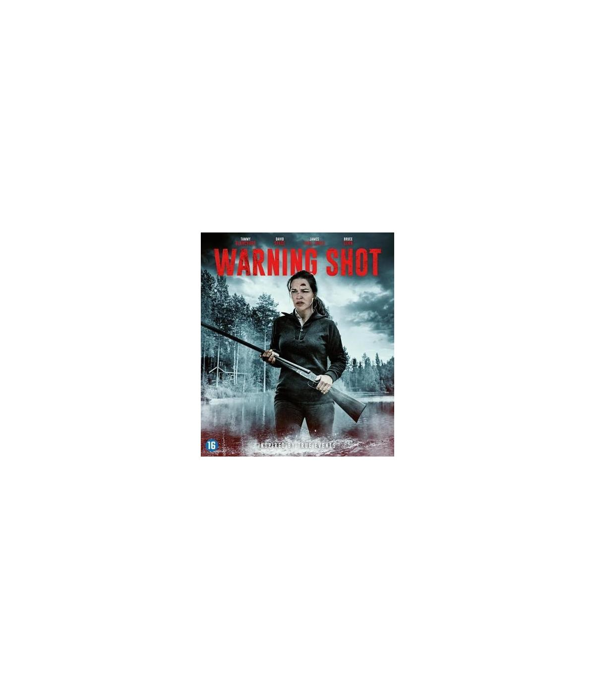 Couverture du DVD de Warning Shot. Une femme tient un fusil, debout près d'un lac. Forêt en arrière-plan.