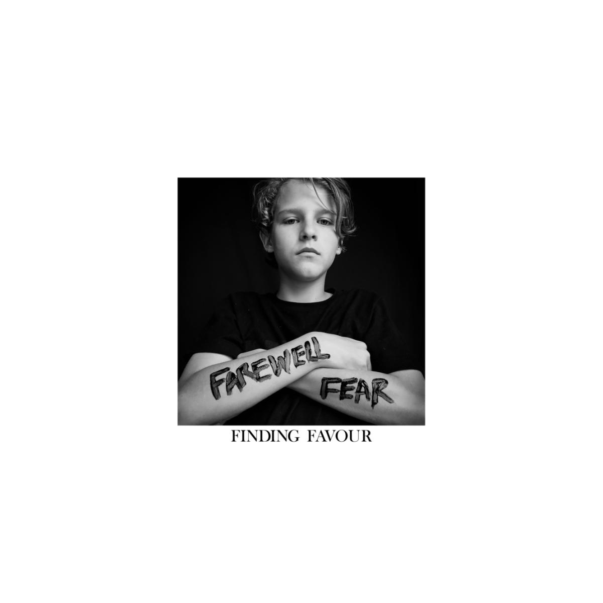 Un jeune garçon avec les mots 'FAREWELL FEAR' sur un bras et 'FINDING FAVOUR' écrit.
