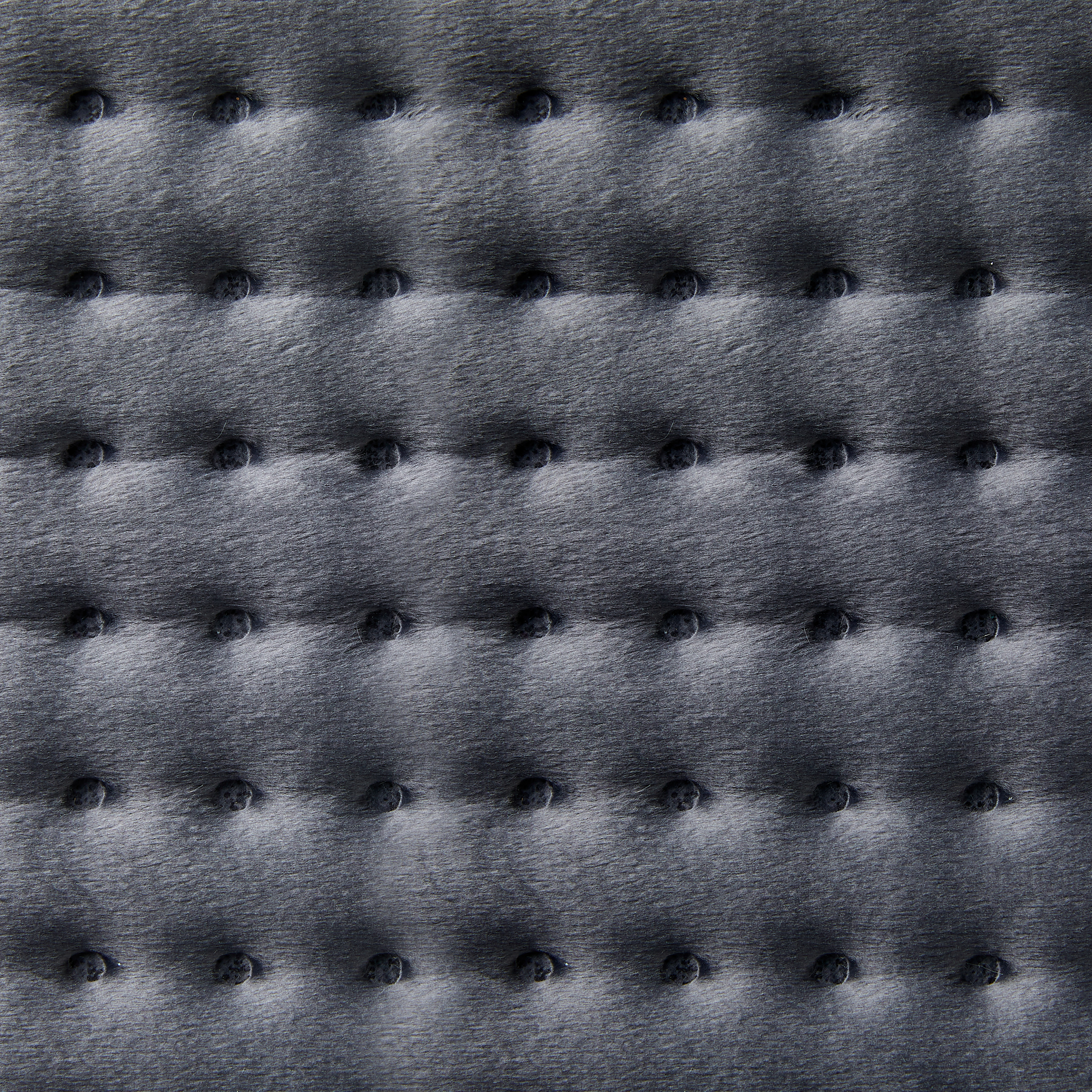 Gros plan d'un tissu gris foncé texturé avec de petits points surélevés bleu foncé espacés uniformément. Motif matelassé.