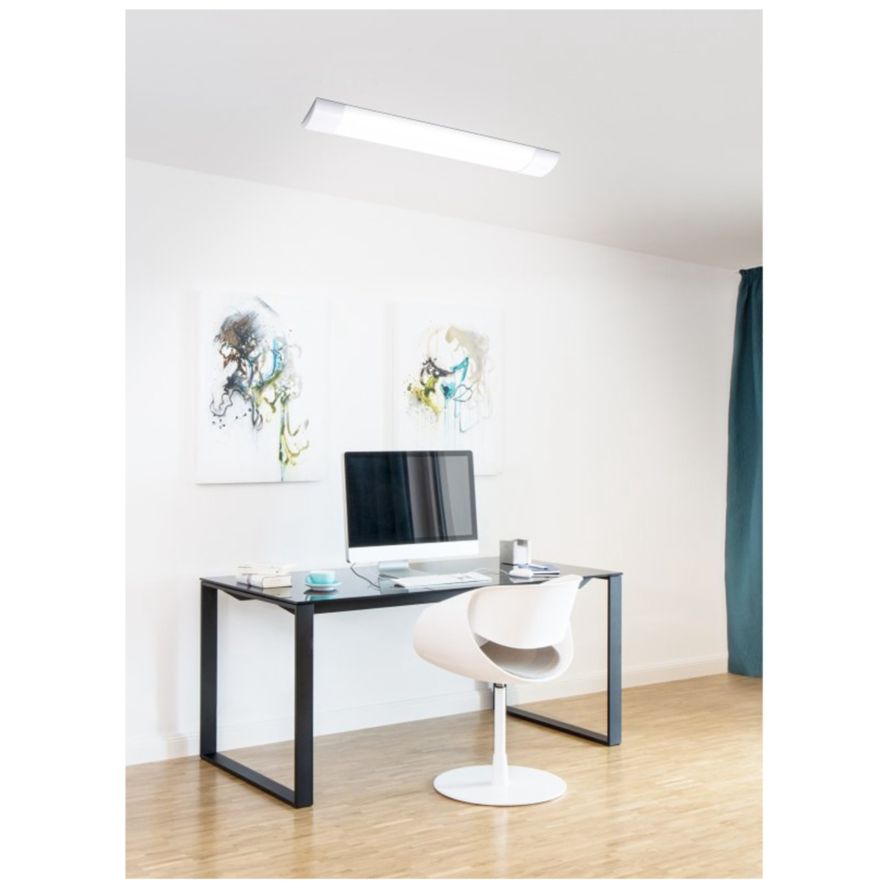 Spazio di lavoro con scrivania nera, sedia bianca e computer. Parete e soffitto bianchi.