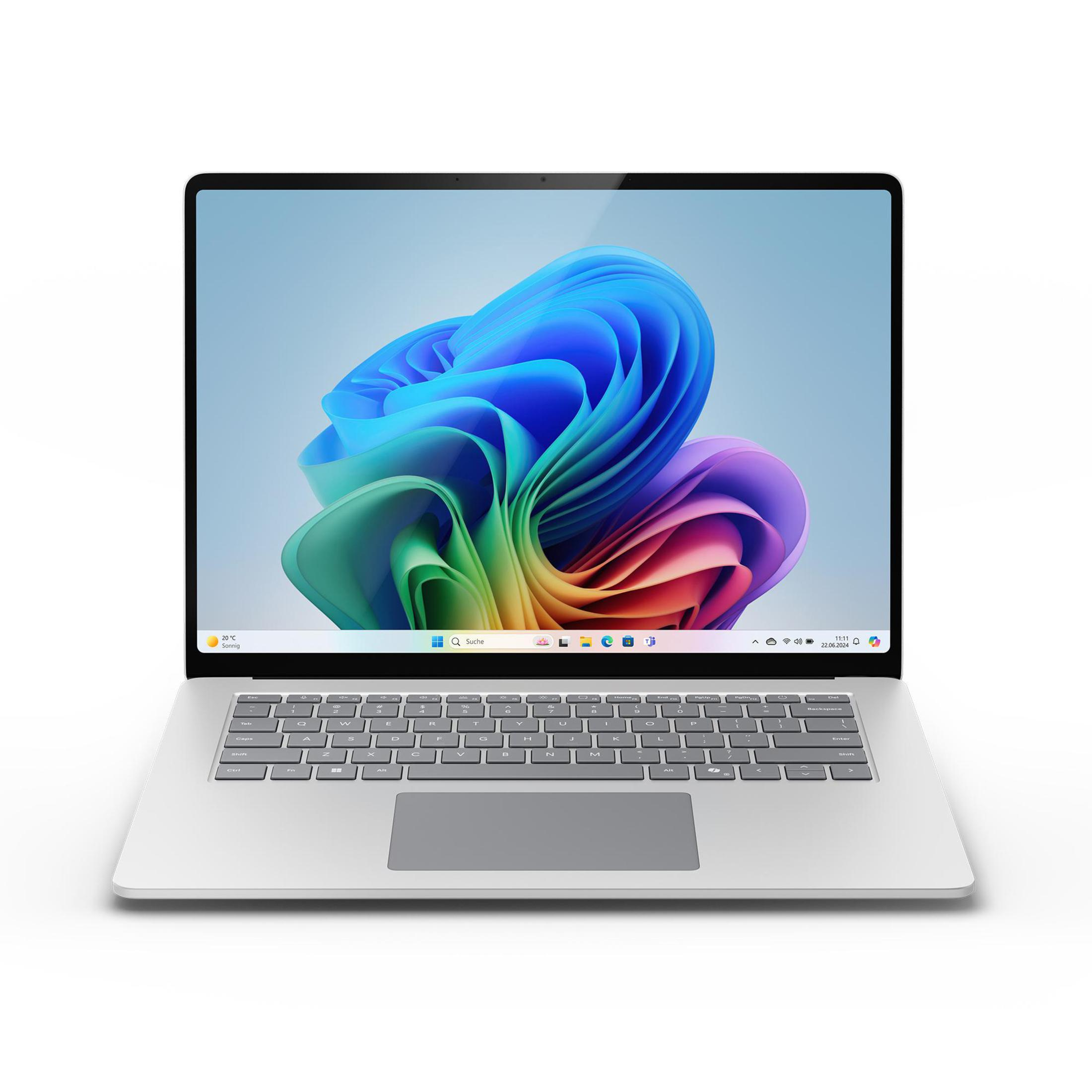 Srebrny laptop na białej powierzchni, pokazujący kolorowy ekran.