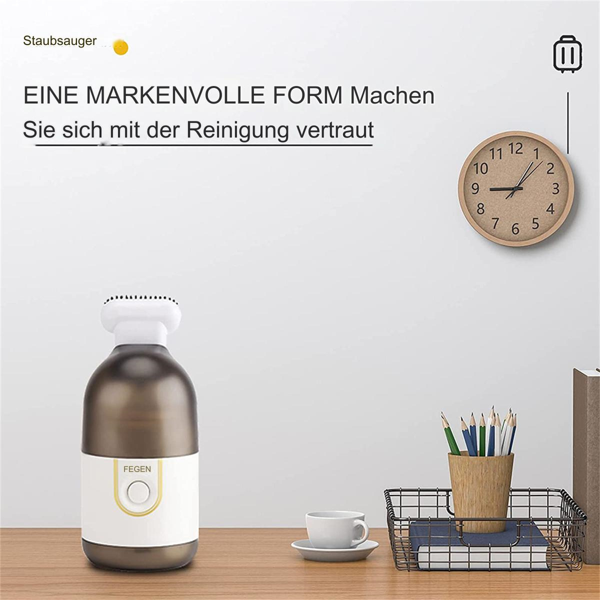 Kleiner Staubsauger mit einer Holzuhr, Bleistiften und einer Kaffeetasse.