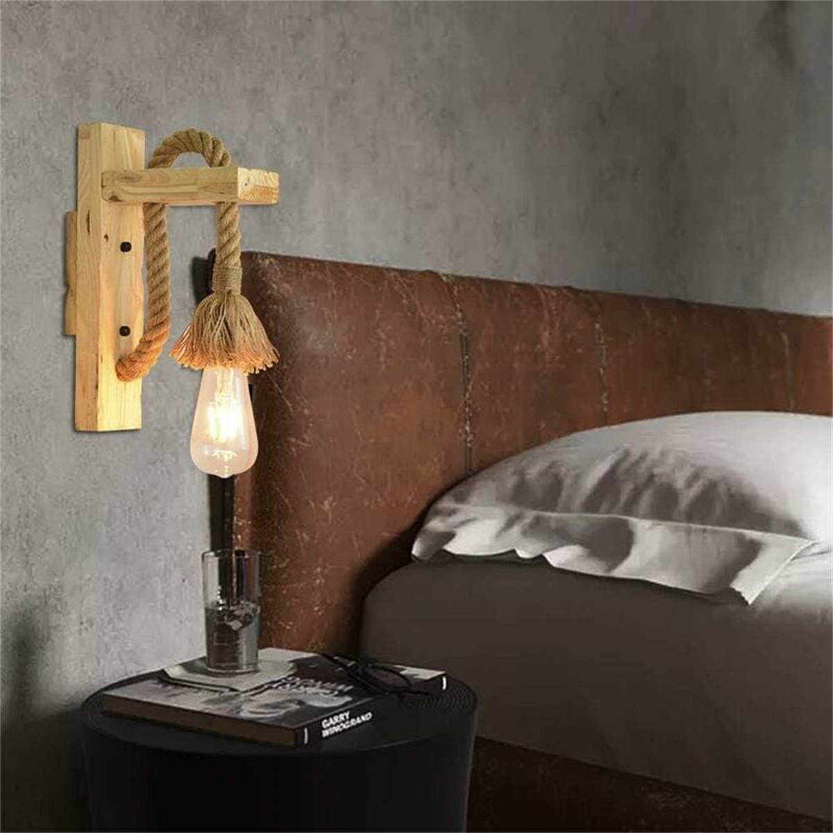 Eine hölzerne Wandlampe mit Seil-Design und Glühbirne, vor grauer Wand.
