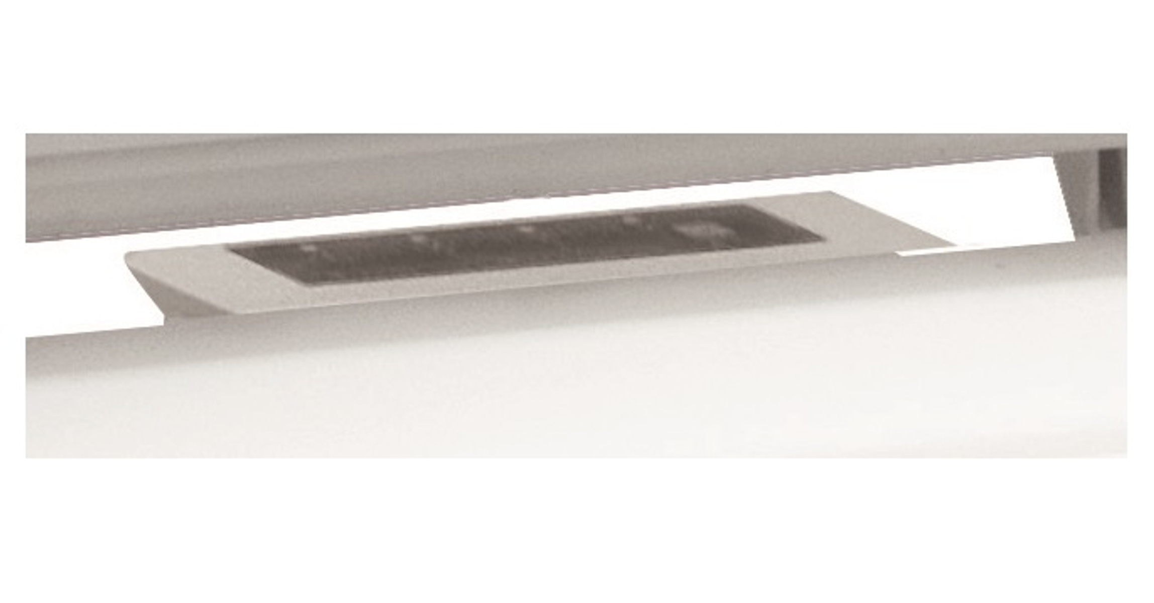 Primer plano de una superficie blanca con un objeto pequeño, rectangular y de color oscuro.
