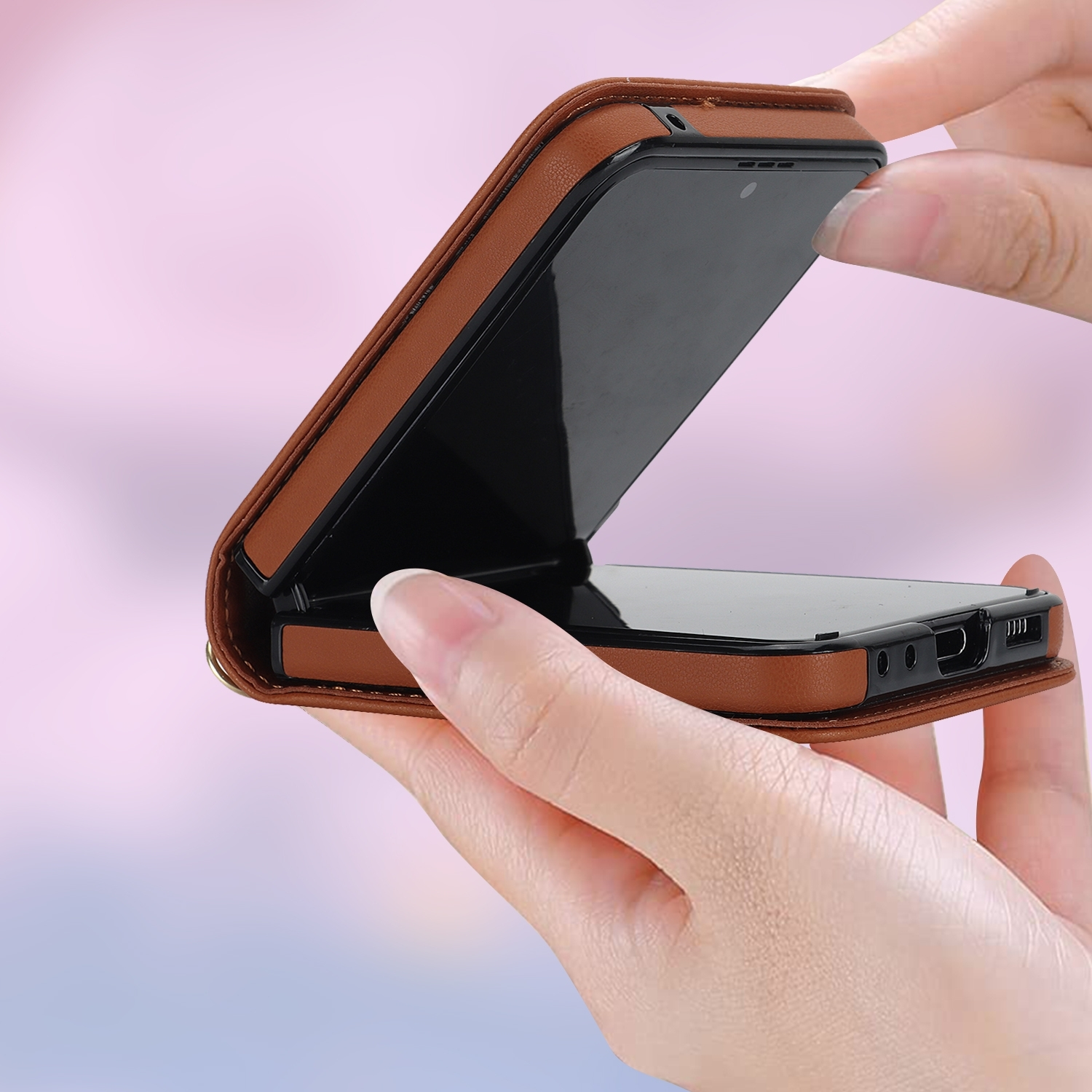 Manos sosteniendo una funda de teléfono marrón abierta, mostrando el teléfono.