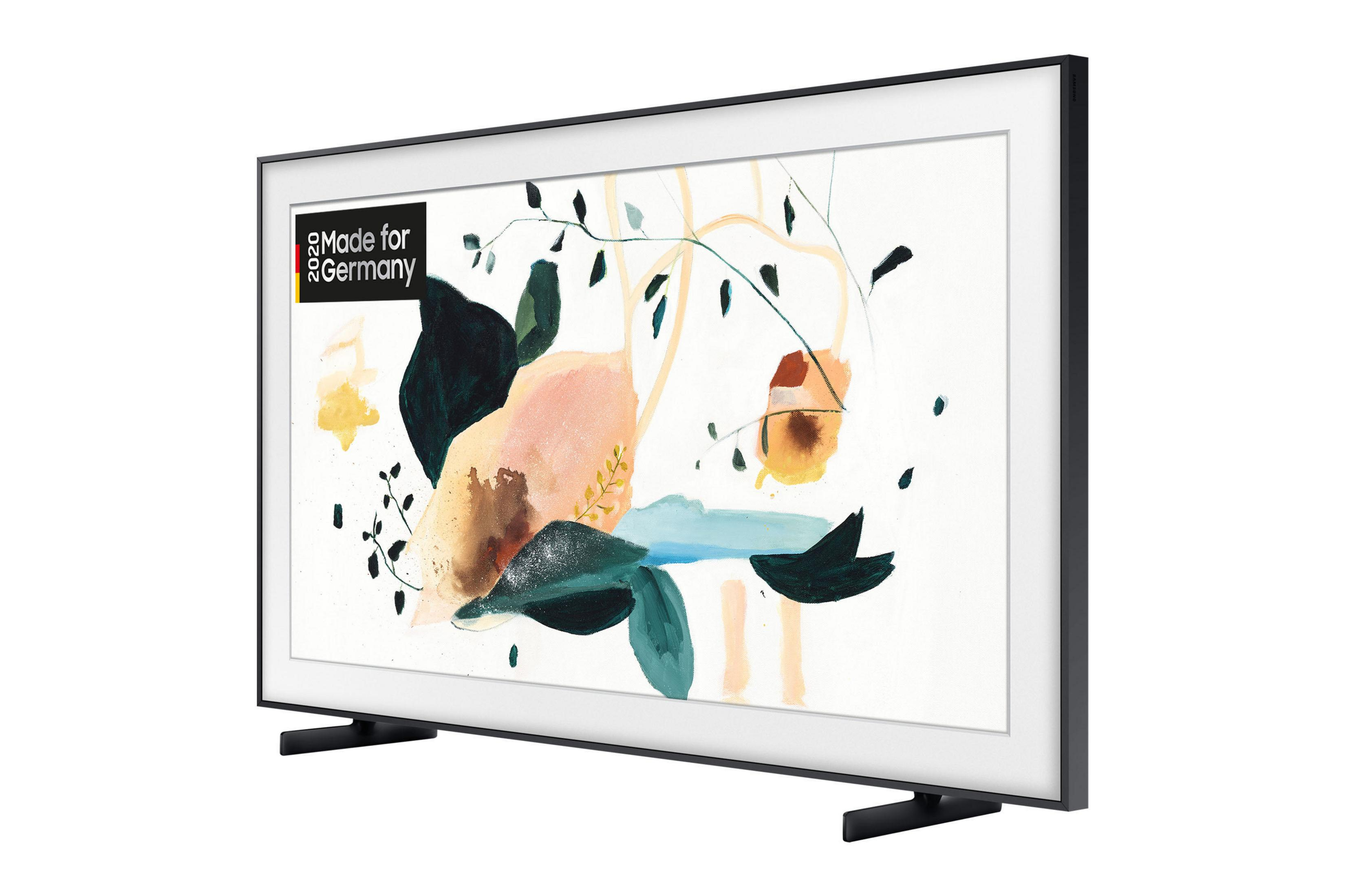 Telewizor Samsung z białą ramą i grafiką na ekranie, wsparty na czarnych nóżkach.