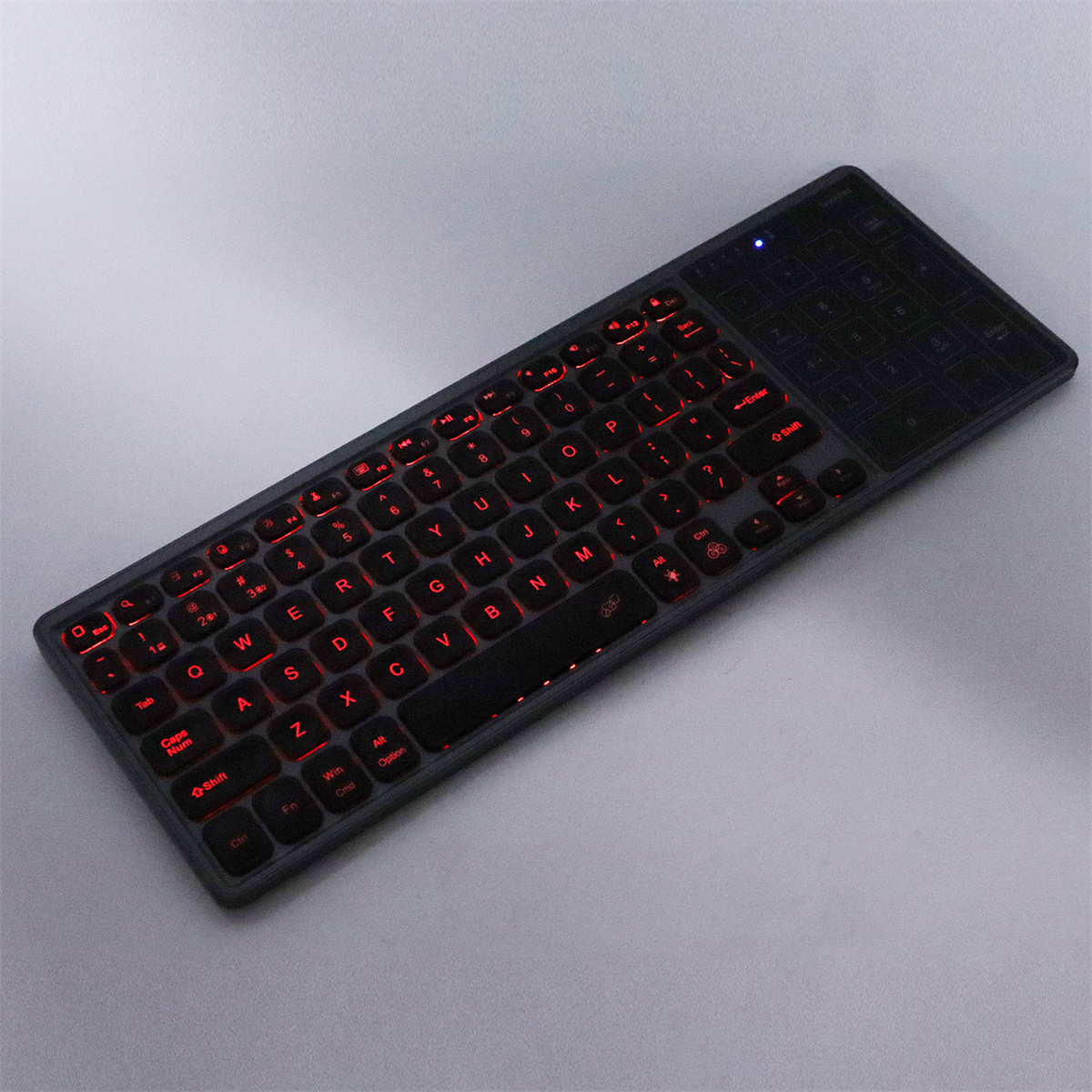 Schwarz beleuchtete Tastatur mit roten Tasten. Die Tastatur hat ein Touchpad und einen Nummernblock.