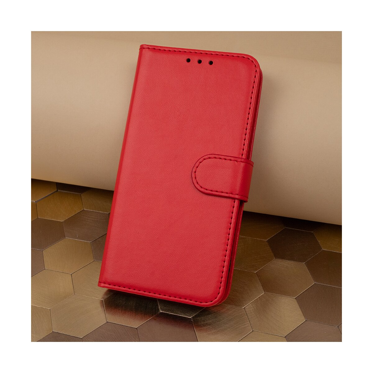 Custodia rossa per telefono, chiusa con chiusura a bottone, su sfondo dorato.