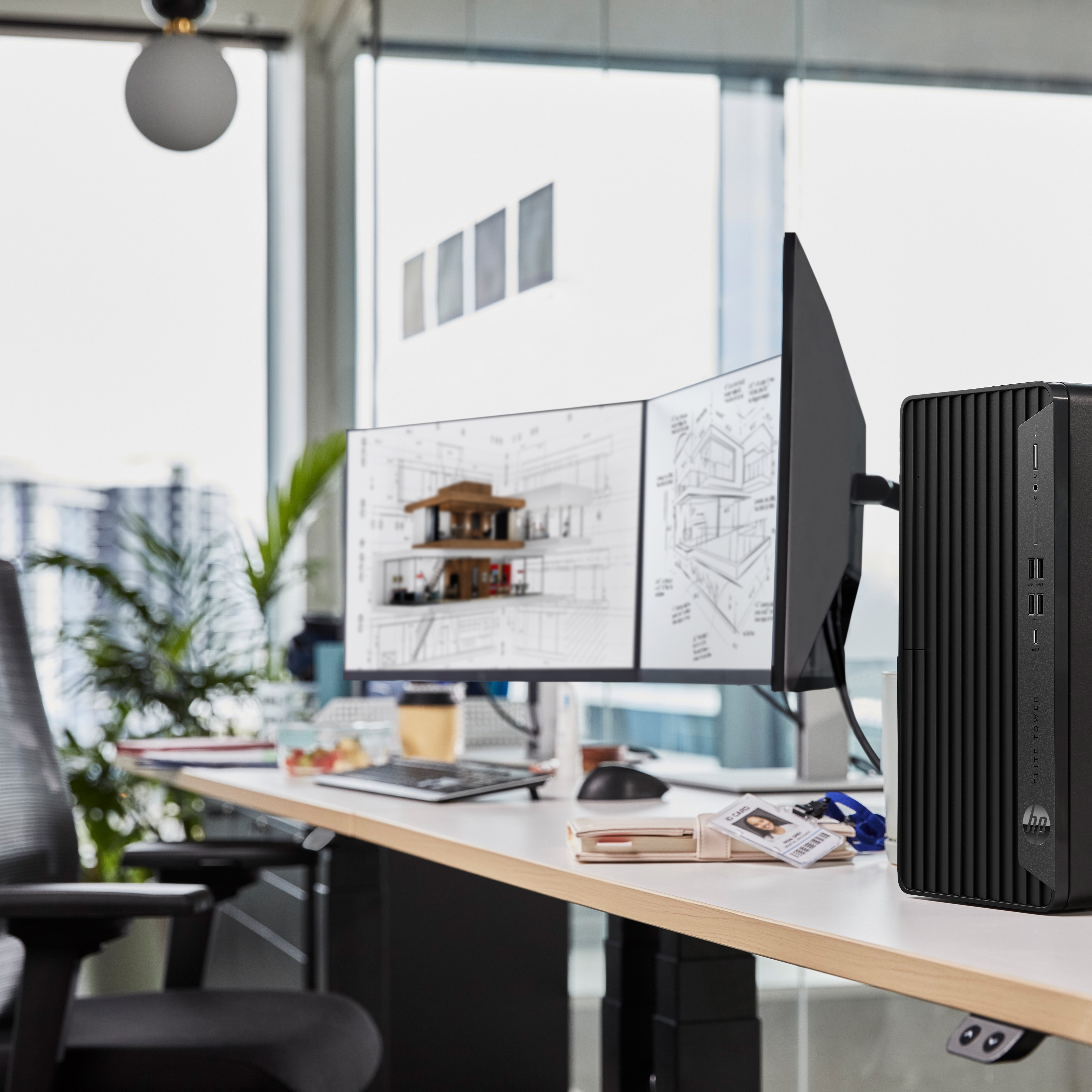 Configurazione scrivania con computer, monitor e PC. Tazza di caffè e fogli sulla scrivania.