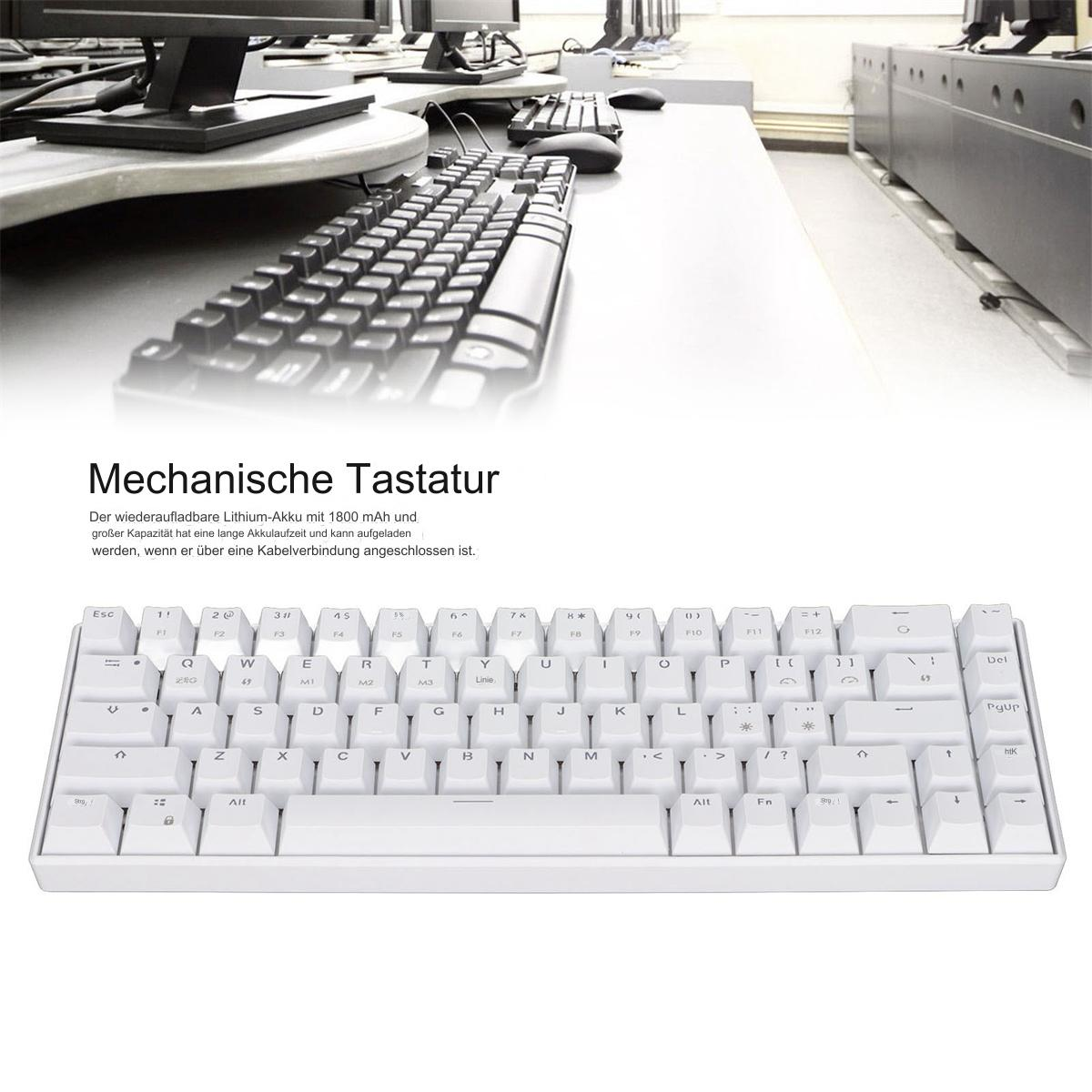 Eine weiße mechanische Tastatur auf einem Schreibtisch mit verschwommenem Hintergrund anderer Tastaturen und Monitore.