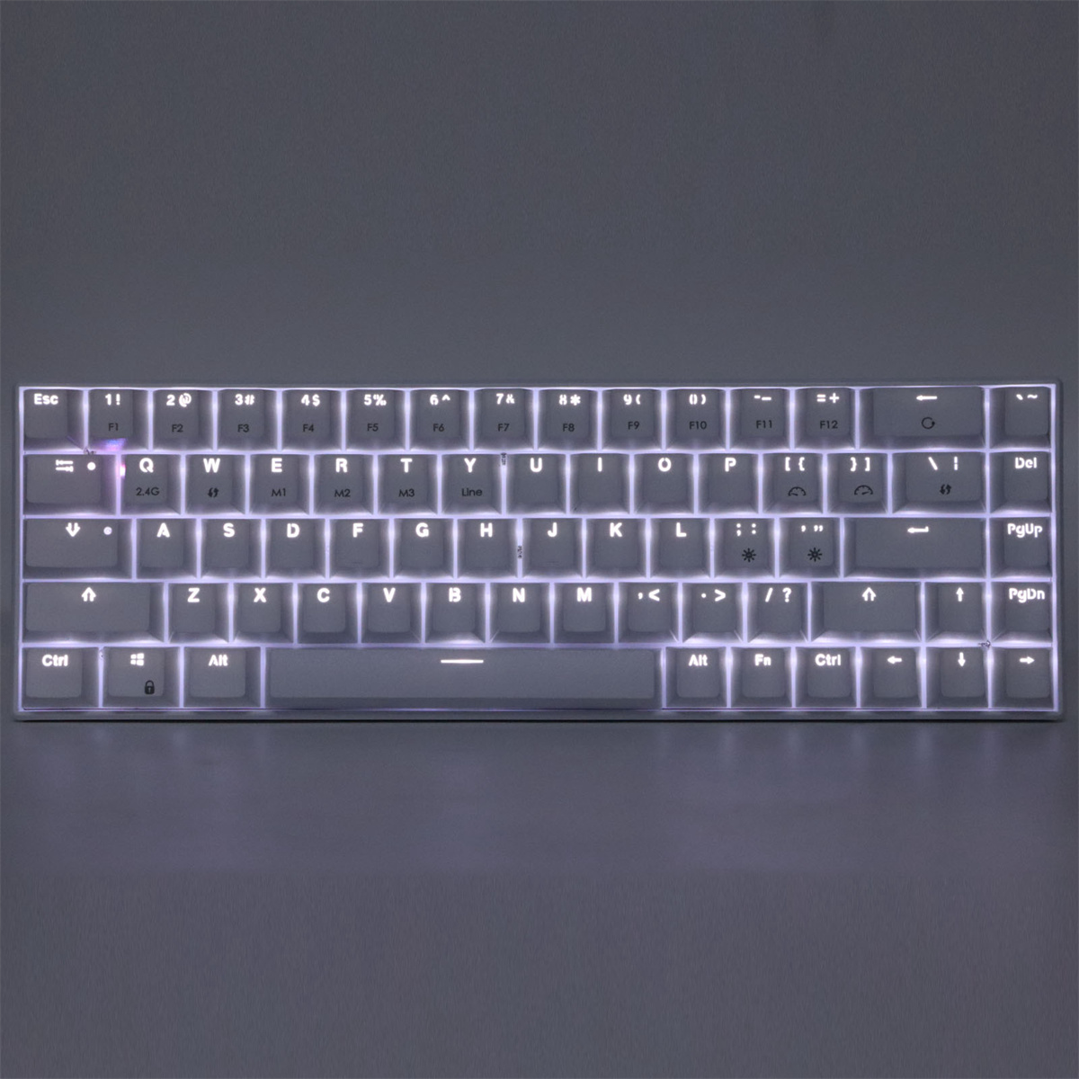 Eine weiße mechanische Tastatur mit weißen Tastenkappen. Die Tasten sind hinterleuchtet. Die Tastatur liegt auf einer grauen Oberfläche.