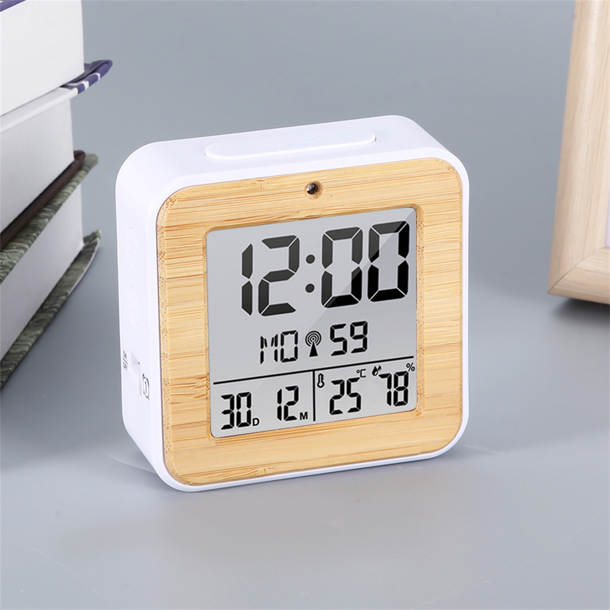 Weißer und Holzmaserung digitaler Wecker. Zeigt Zeit, Datum, Temperatur und andere Statussymbole an.