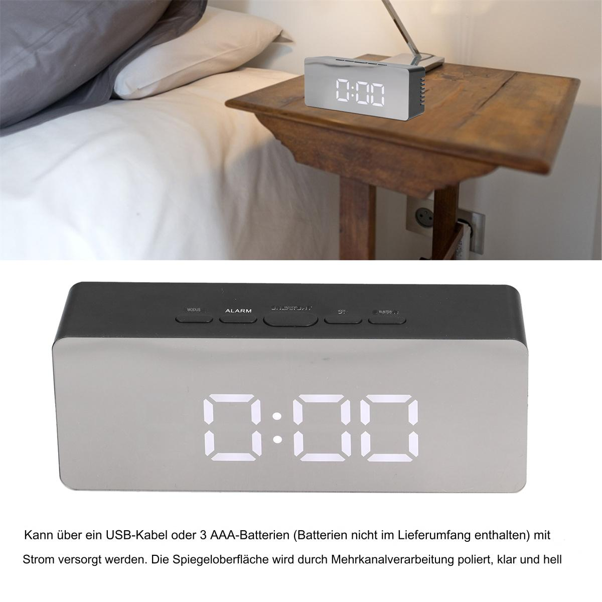 Digitaluhr auf einem Holztisch neben einem Bett. Weißer Hintergrund.