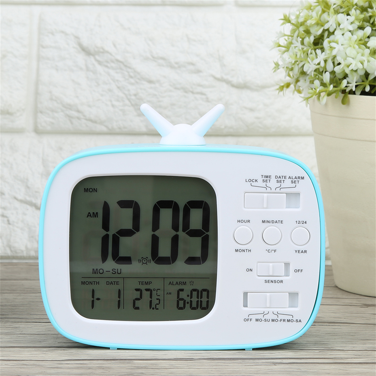 Digitaler Wecker, blau und weiß. Zeigt Zeit, Datum und Temperatur an.