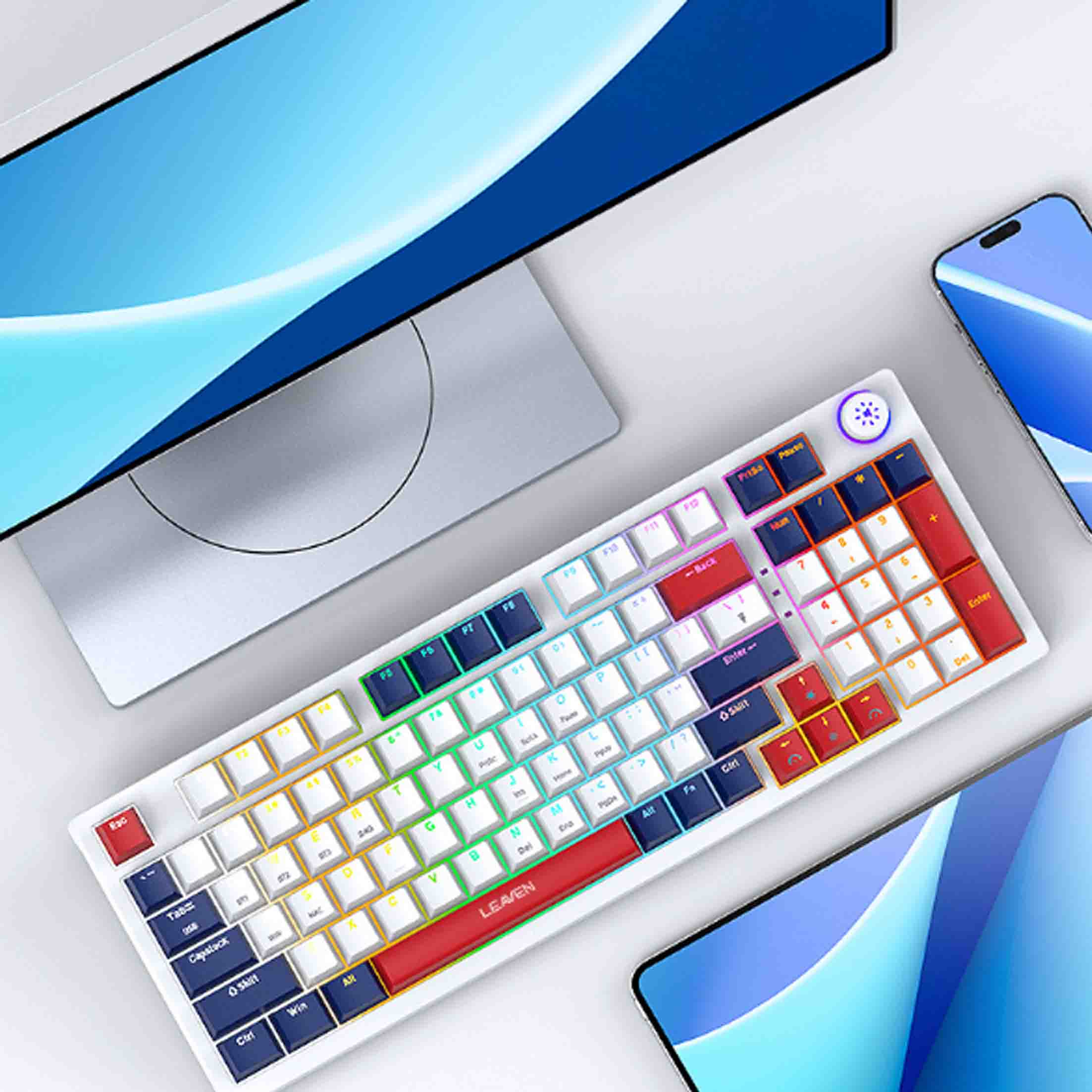 Eine weiße Tastatur mit bunten, hintergrundbeleuchteten Tasten, ein Monitor und zwei Telefone sind sichtbar.